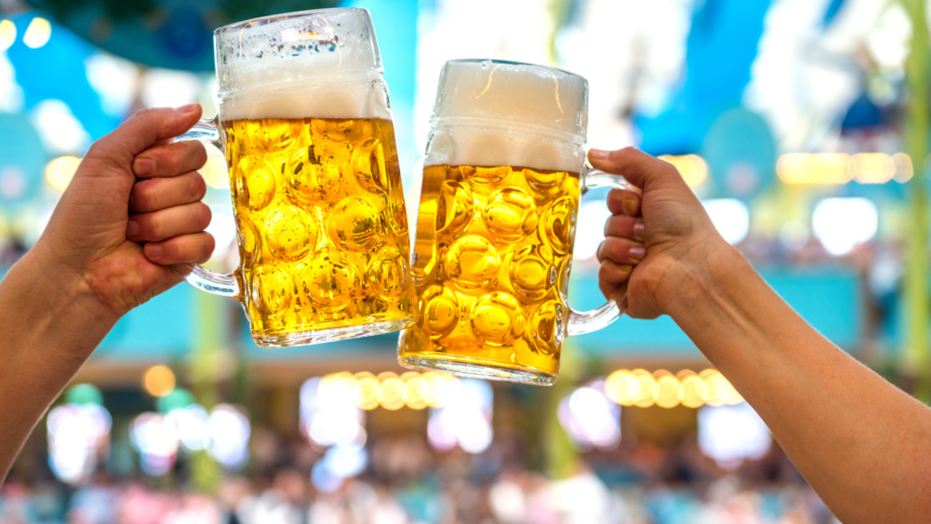 Two mugs full of beer toasting